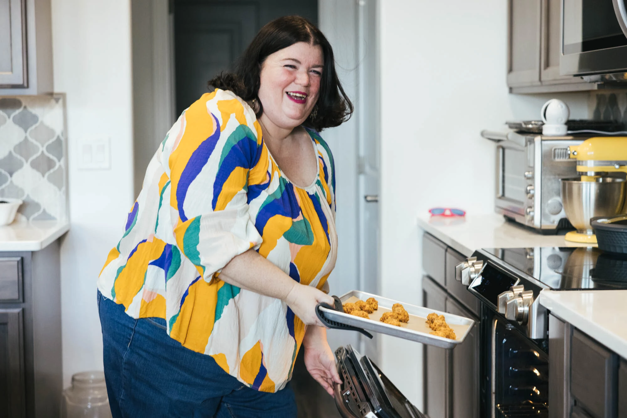 Tammilee putting a tray in the oven.